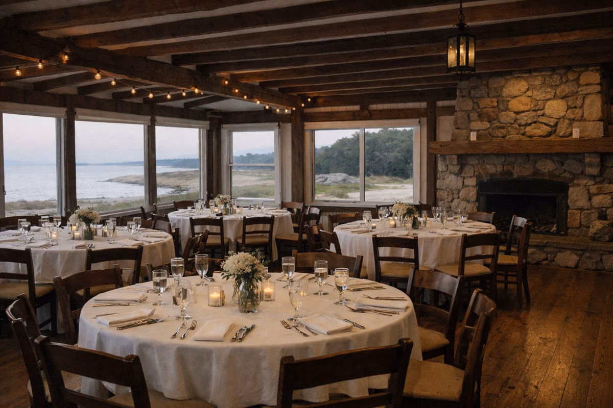 Rustic event hall with timber beams, stone fireplace and set tables