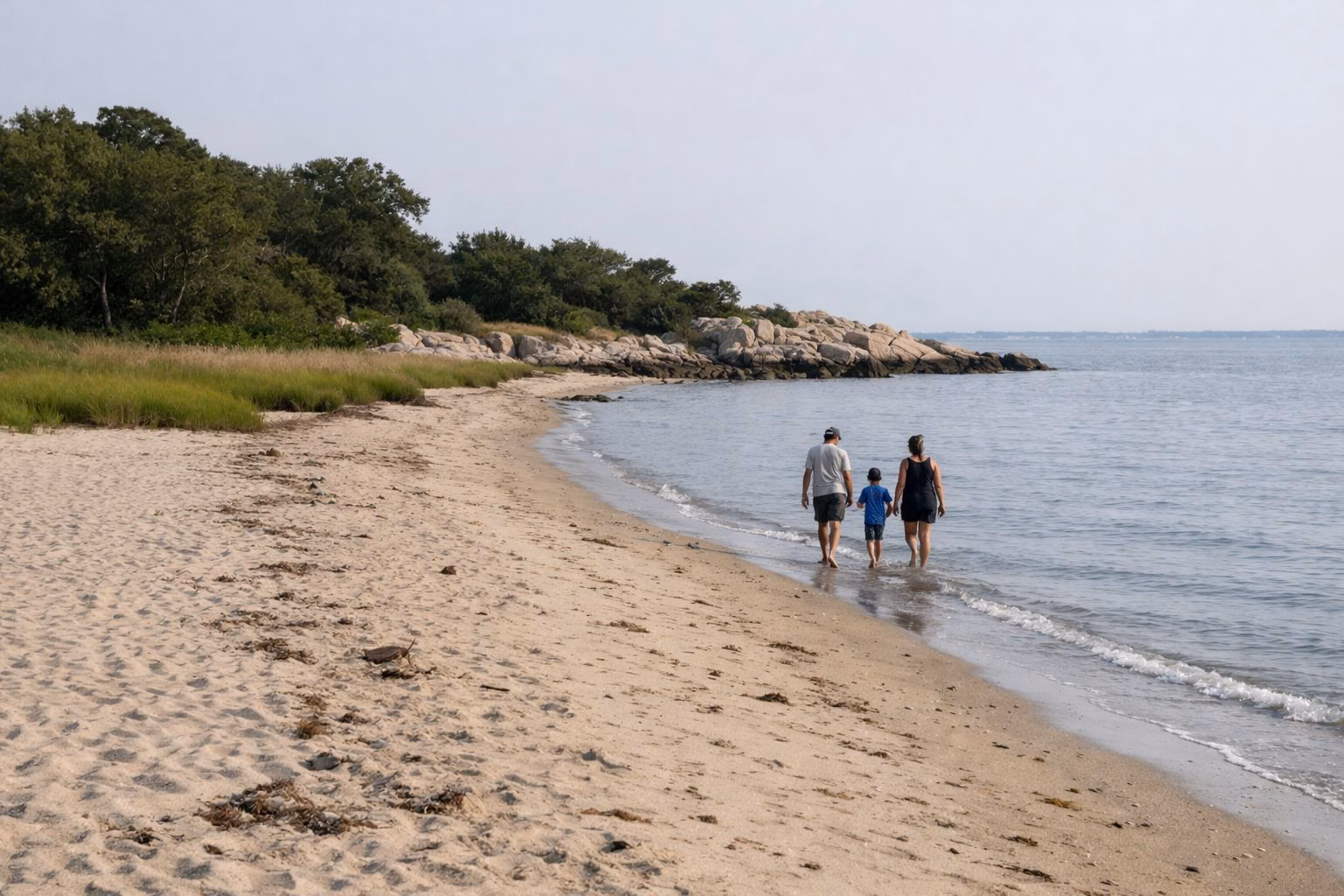 Family walking along the edge of a sandy beach