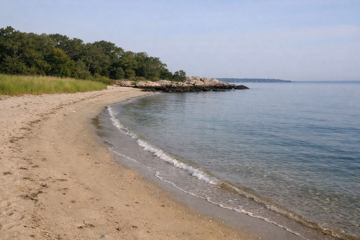 Gently sloping sandy beach and calm clear water on a summer morning